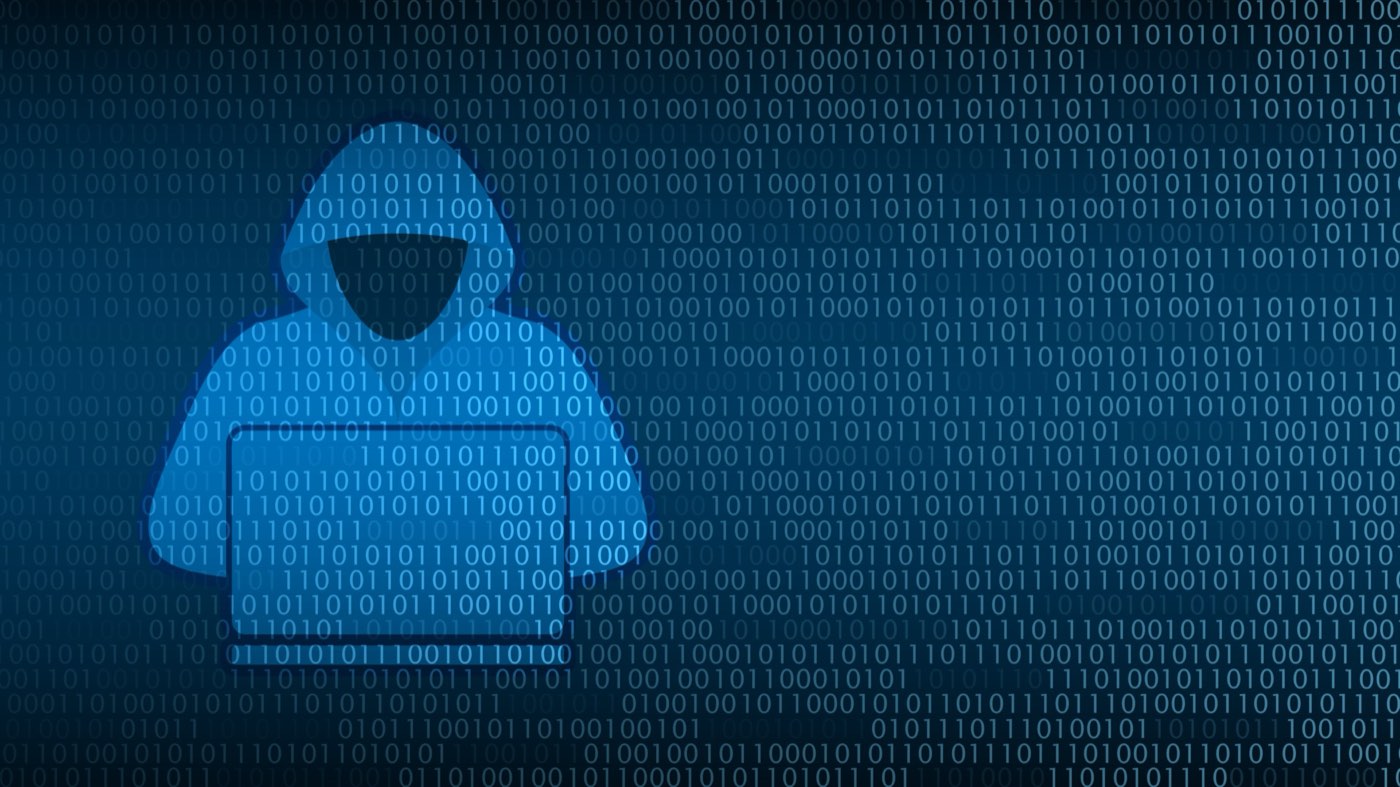 A hooded figure at a laptop formed from streams of binary code on a dark background, representing an anonymous, automated cyberattacker